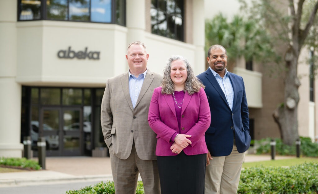 Abeka Representatives standing in front of the Abeka office building
